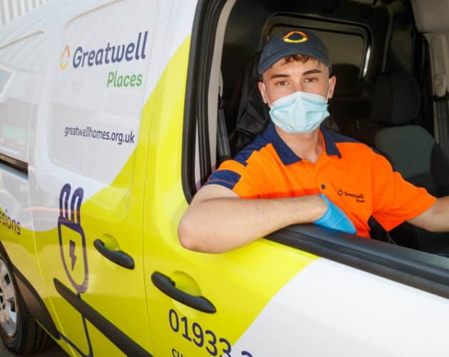 A person wearing a mask and cap sits in the driver's seat of a Greatwell Places van, ready to tackle damp and mould issues. They lean out the window in an orange and navy uniform while the van's logo and contact information are prominently displayed. ©Mobysoft