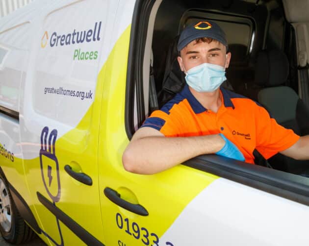 A delivery person in an orange uniform, cap, and face mask sits in a white and yellow "Greatwell Places" van. With their elbow resting on the window frame, they seem ready to tackle any task—be it delivering parcels or addressing damp and mould issues with efficiency. ©Mobysoft