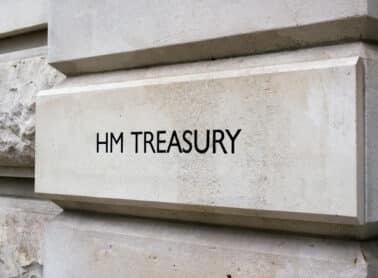 A stone wall with the words "HM TREASURY" engraved on it, indicating the location of the UK's government department responsible for economic and financial matters. The surface is smooth with some rougher stone texture visible on the left. ©Mobysoft